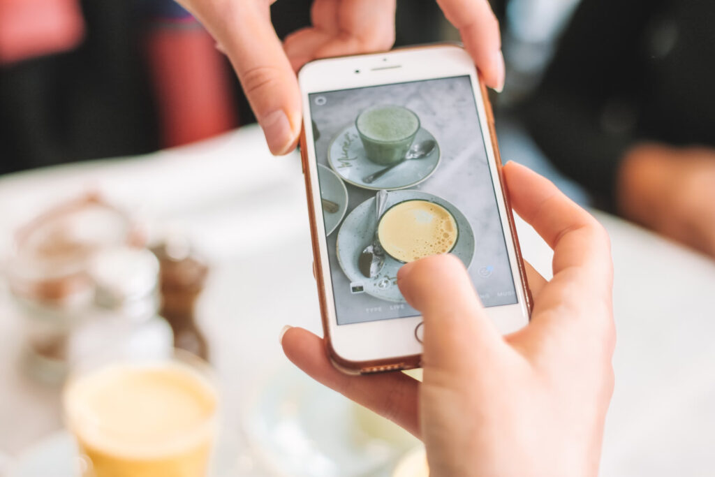شخص يحمل هاتفا يأخذ قصة Instagram لاثنين من القهوة.