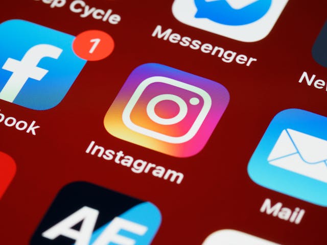 أيقونة تطبيق Instagram بخلفية حمراء على شاشة الهاتف الذكي.