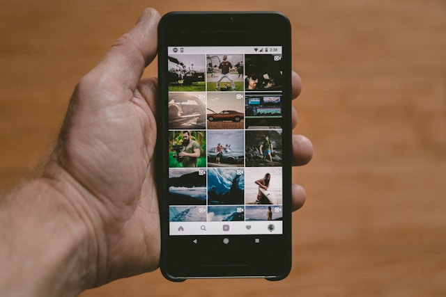 شخص يمسك بهاتفه الذكي مع عرض موجز Instagram على الشاشة.