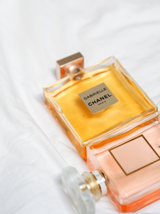 زجاجات عطر زجاجية على قماش أبيض.