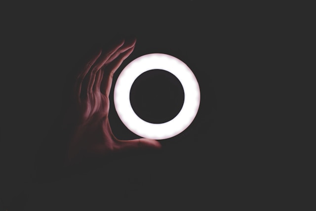 يد تحيط بمصباح دائري LED أبيض اللون.