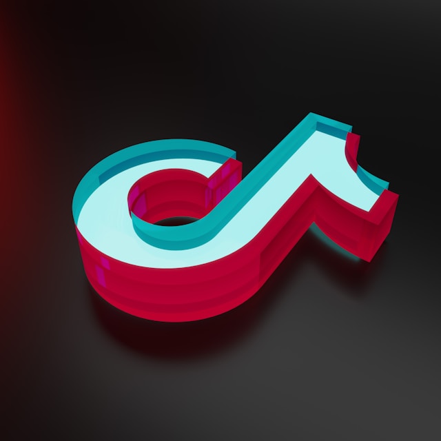 شعار TikTok باللون الأحمر والأبيض والأزرق على خلفية داكنة.