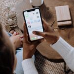 شخصان ينظران إلى هاتف ذكي مع تطبيق TikTok معروض على الشاشة.
