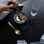 Ein Food-Influencer, der eine ästhetische Joghurtschale fotografiert.