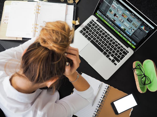 Frau sitzt frustriert vor ihrem Laptop.