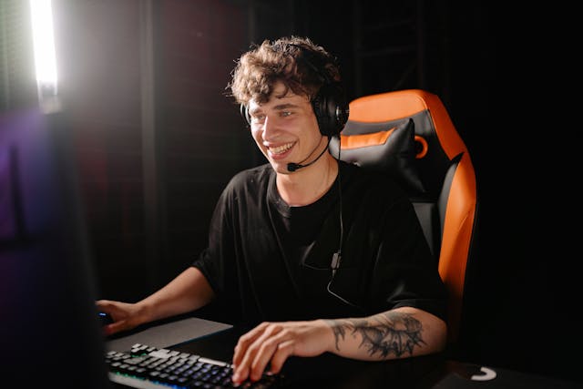 Eine Person, die fröhlich an ihrem Computer spielt.