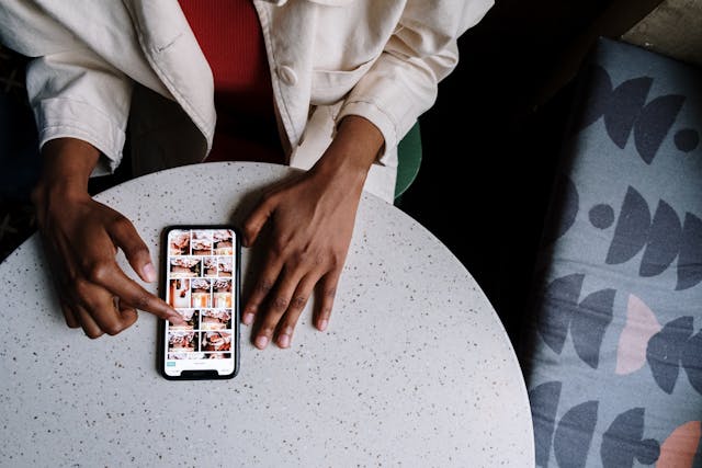 Eine Person scrollt auf ihrem Smartphone durch einen Instagram-Feed.