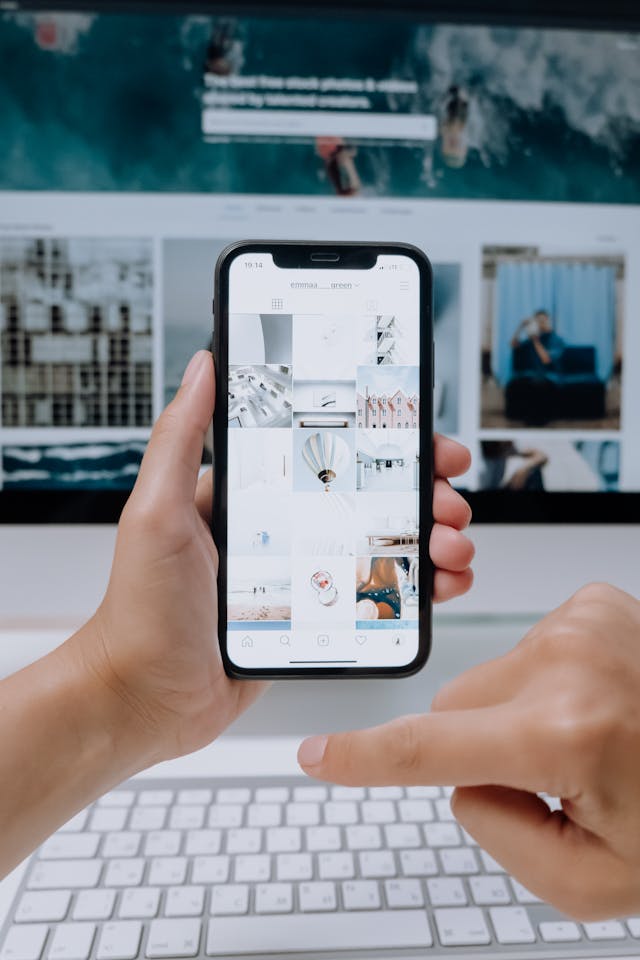 Eine Person hält ein Smartphone in der Hand, auf dessen Bildschirm ein Instagram-Feed angezeigt wird.