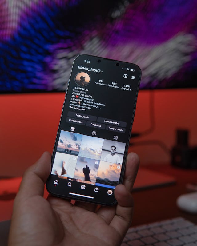 Eine Person hält ein Smartphone in der Hand, auf dessen Bildschirm ein Instagram-Feed angezeigt wird.