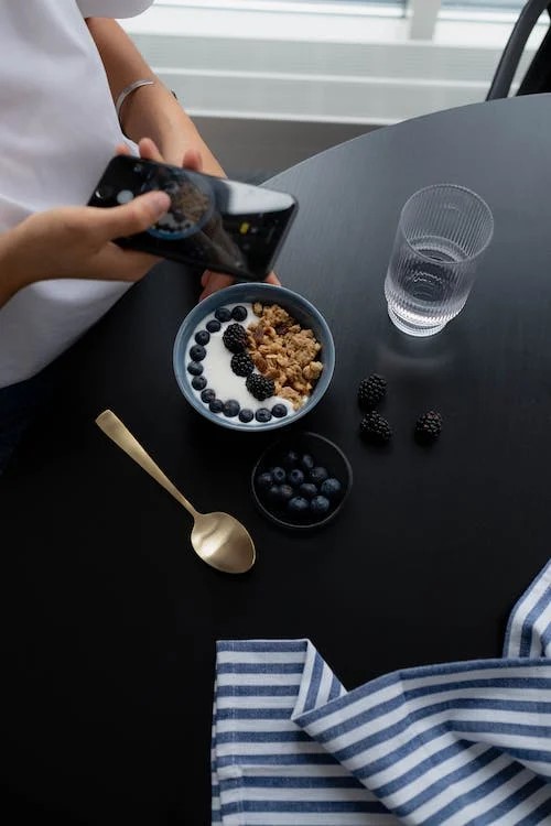 Un influencer gastronómico haciendo una foto a un estético bol de yogur.