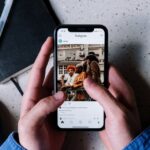 Una persona sujeta un teléfono con ambas manos y utiliza la aplicación Instagram.