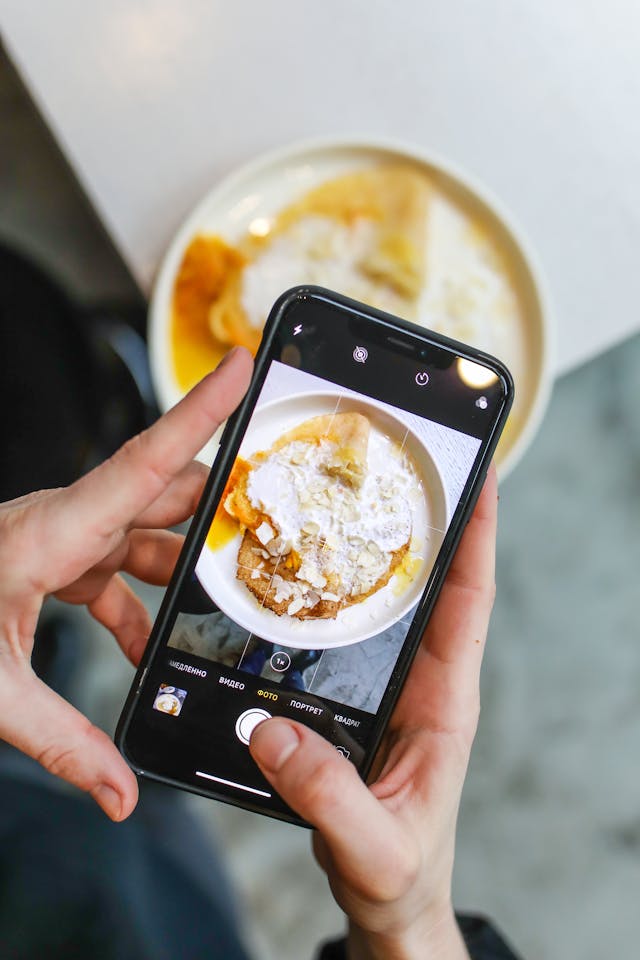 Una persona graba con su smartphone algún alimento.