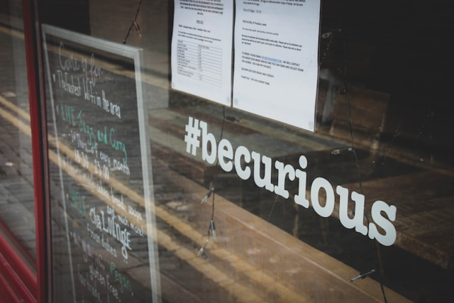 Un escaparate con "#becurious".