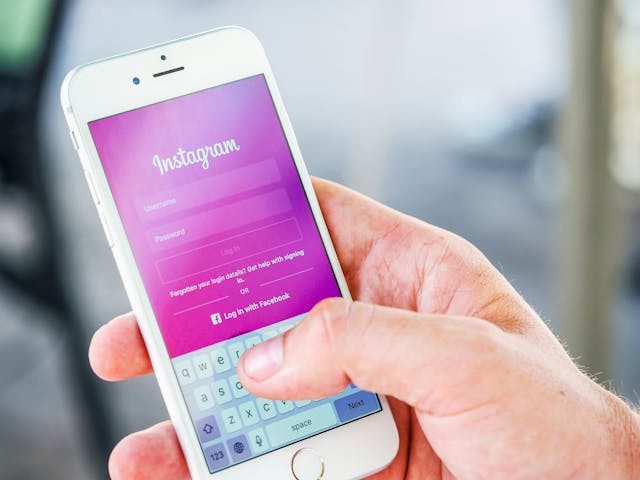 Una persona sostiene un smartphone con la página de inicio de sesión de Instagram en la pantalla.