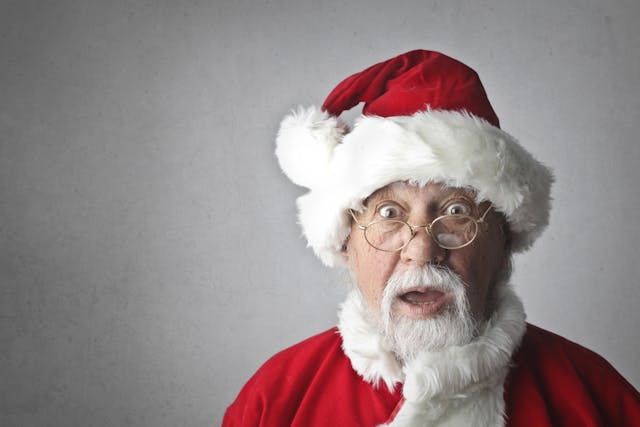 Un hombre vestido de Papá Noel hace una mueca divertida y parece sorprendido