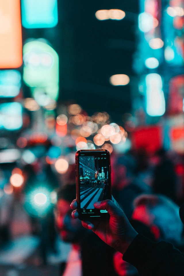 Una persona captando imágenes de una ciudad por la noche.