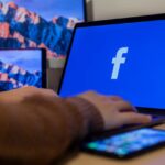 Alguien usando un portátil mostrando el logo de Facebook.
