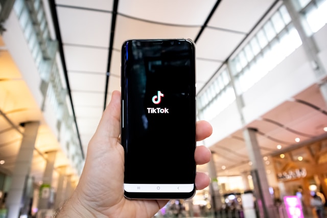 Una persona sostiene un smartphone con TikTok cargando en la pantalla.