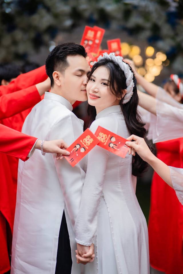 Un novio besa a su novia cogidos de la mano.