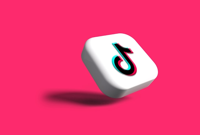 Logotipo de TikTok en 3D sobre fondo rosa.