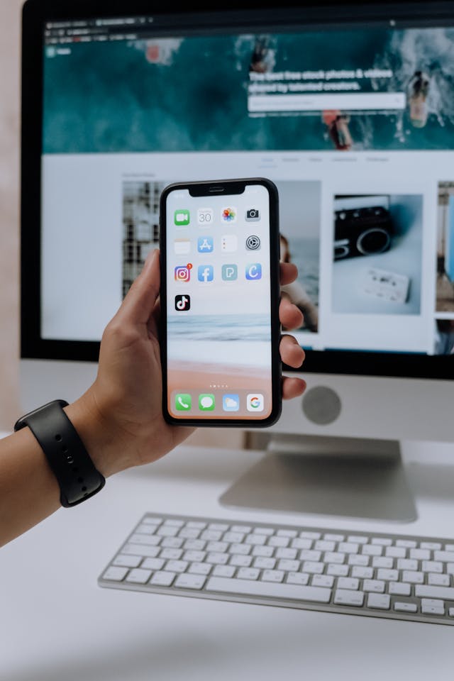 Una persona con un smartphone en la mano y la aplicación TikTok en la pantalla.