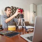 Un hombre con camisa de cuadros preparando su cámara de vlogging.