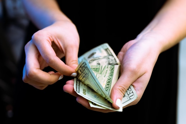 Une personne compte des billets de 20 dollars.
