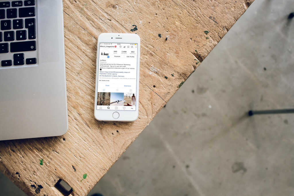 Un smartphone montre un compte Instagram avec une icône de profil, une biographie et trois posts.