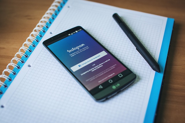 La page de connexion d'Instagram est affichée sur un smartphone posé sur un ordinateur portable.