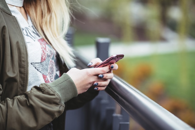 Une personne tenant et utilisant son smartphone.