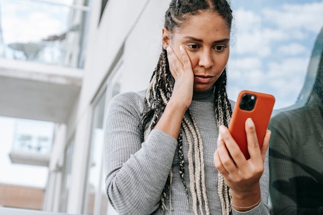Une personne utilisant son téléphone et ayant l'air inquiet.