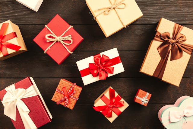 De nombreux coffrets cadeaux de différentes couleurs et tailles sur une surface en bois.