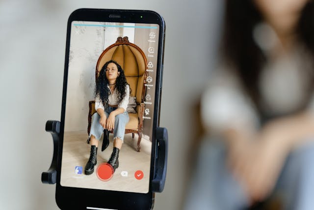 Un téléphone enregistre une personne assise sur une chaise.