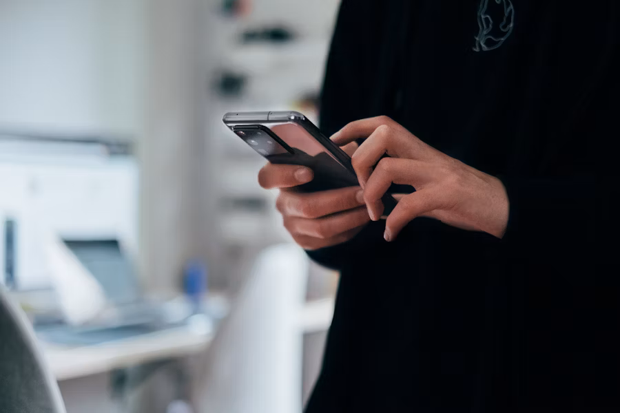 Une personne fait défiler son smartphone d'un seul doigt. 
