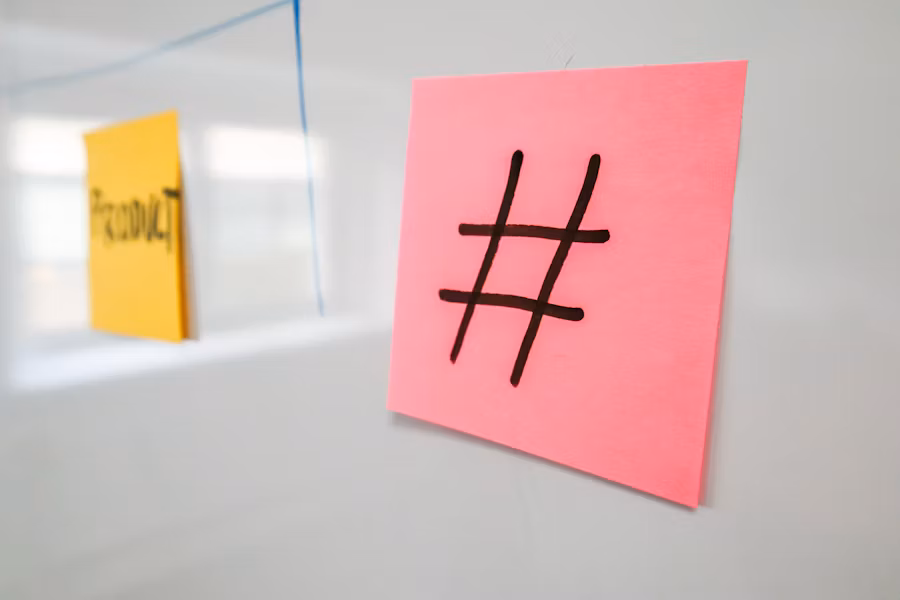 Un hashtag noir est dessiné sur une note autocollante rose. 
