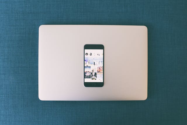 Un smartphone posé sur un ordinateur portable et affichant des photos Instagram.