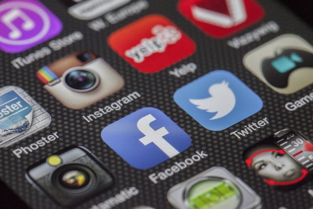 Gros plan d'un smartphone affichant des icônes d'applications de médias sociaux, dont Instagram.