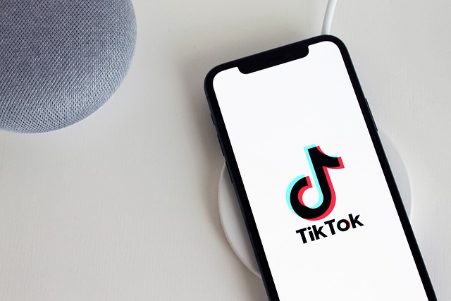 Un smartphone chargé sur un chargeur sans fil et affichant le logo TikTok sur son écran.