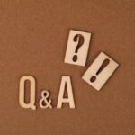 Caractères en bois épelant "Q&A", avec des points d'interrogation et d'exclamation à proximité.