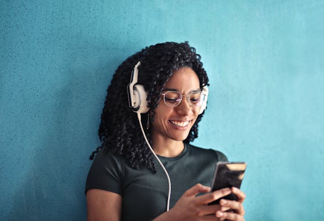 Une personne écoutant de la musique en regardant son téléphone.