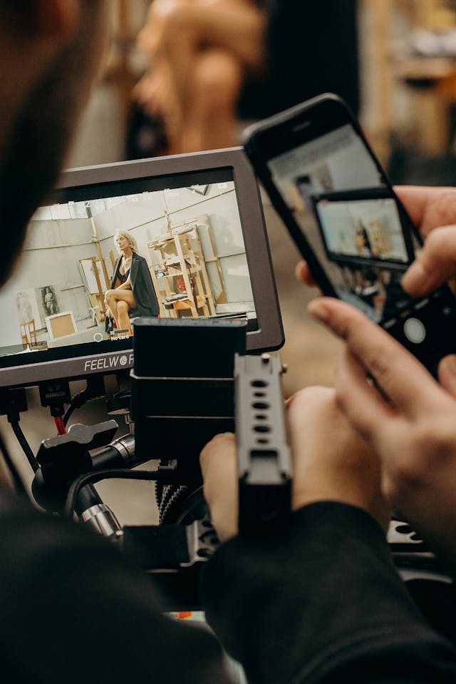 Una persona che tiene uno smartphone accanto a un tablet durante un servizio fotografico per influencer.