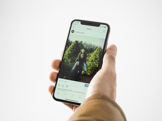 Una persona tiene in mano un telefono che mostra il post di Instagram di qualcuno.
