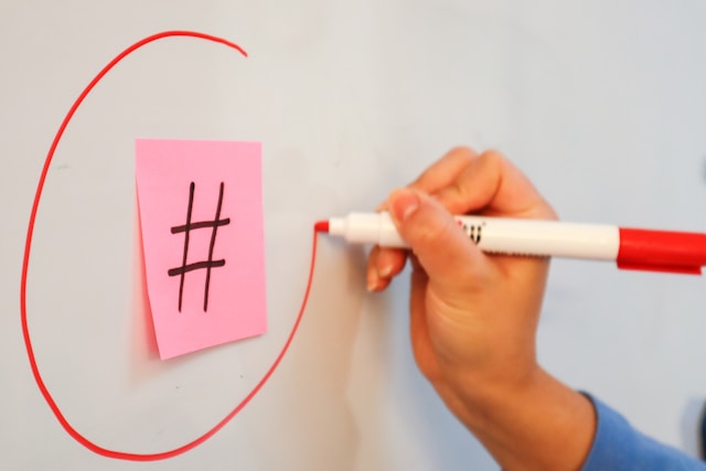 Una persona sta cerchiando un segno di hashtag su una lavagna.