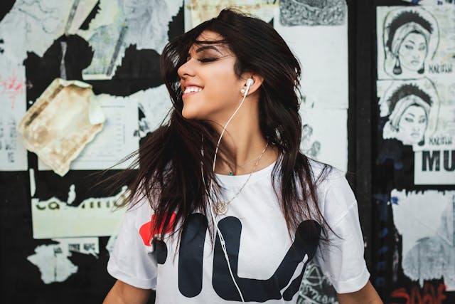 Una persona che sorride mentre ascolta la musica in cuffia.