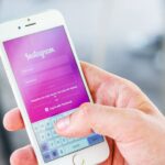 Una persona che tiene in mano uno smartphone con diversi rulli di Instagram visualizzati sullo schermo.