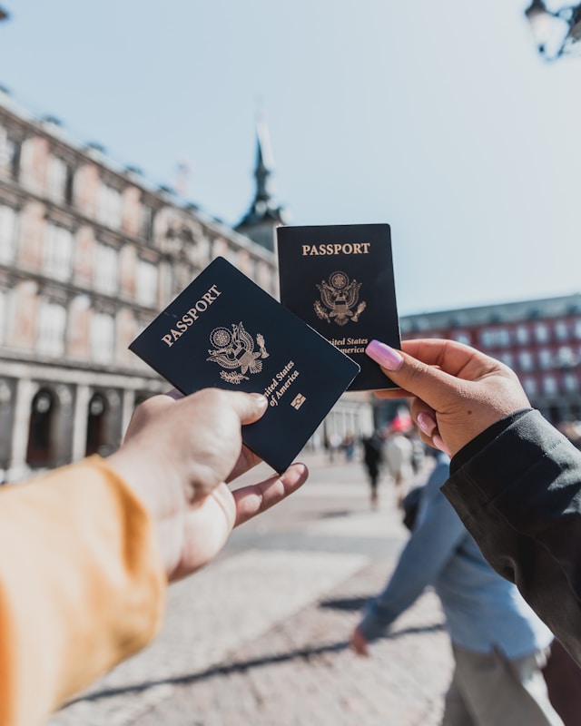 Due persone che tengono i loro passaporti davanti alla telecamera.