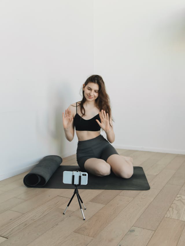 Una donna si filma mentre pratica yoga.