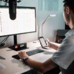 Una persona che sfoglia l'elenco dei propri video di YouTube sul proprio laptop e telefono.