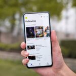 Un telefono che mostra la pagina iniziale dell'app Twitch con diversi flussi e categorie.