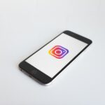 O logótipo do Instagram no ecrã de um dispositivo móvel com um fundo branco.